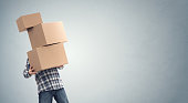 Man holding heavy cardboard boxes relocation, moving house or courier delivery