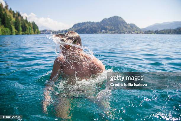 wet man shaking hair in lake - appearance stock-fotos und bilder