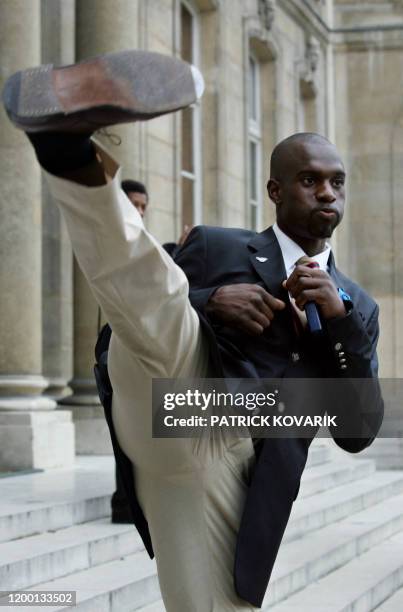 Pascal Gentil, médaillé de bronze en taekwondo aux Jeux olympiques d'Athènes, fait une démonstration sur le perron du palais de l'Elysée après avoir...