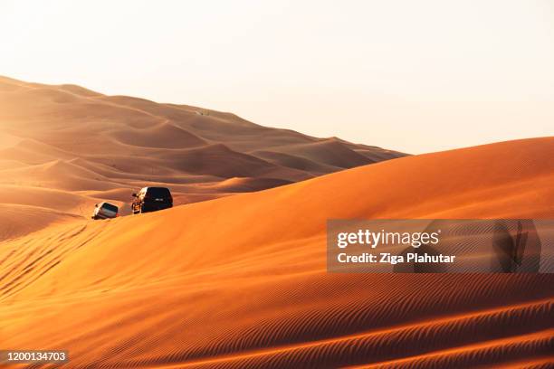 wüste sanddünen und safari-erlebnis bei sonnenuntergang - dubai desert stock-fotos und bilder