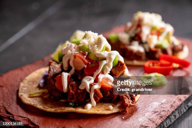 beef carne asada mexican tijuana style street food tacos with marinated steak, cilantro, onion, cotija cheese and sour cream - mexican food stock pictures, royalty-free photos & images