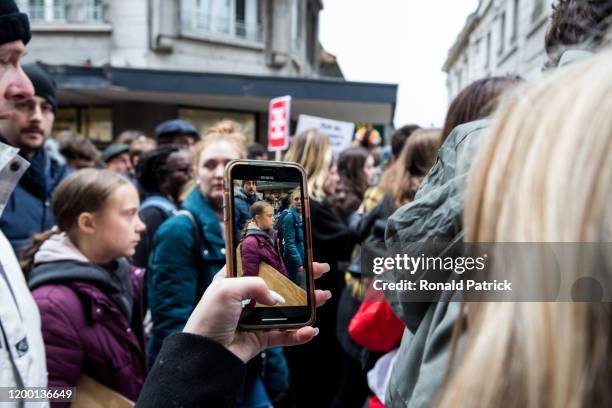 Demonstrator takes a picture of Swedish climate activist Greta Thunberg with her phone, as she marches at a climate change protest where she later...