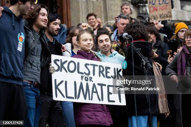 Swedish climate activist Greta Thunberg holds up a sign featuring the main slogan of her movement, 'School strike for the climate', after speaking to...