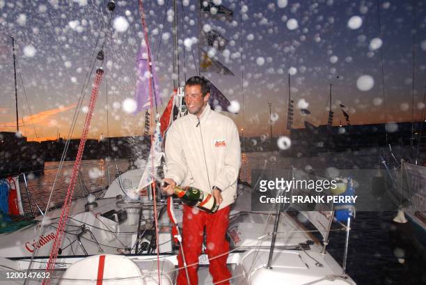 Le navigateur Armel Le Cleac'h secoue une bouteille de champagne à son arrivée dans le port de Saint-Nazaire dans la nuit du 21 au 22 août 2003, pour...