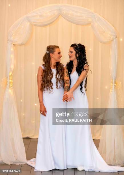 Robyn Peoples and Sharni Edwards pose for photographs after becoming the first same-sex couple to get married in Northern Ireland in Carrickfergus,...