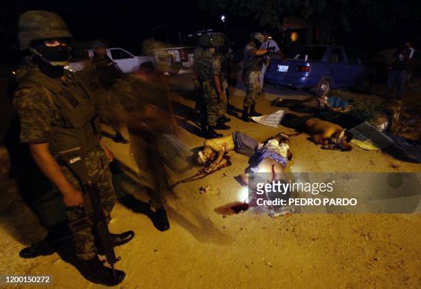 Mexican soldiers check the dead bodies of six men found next to a road between Acapulco and Mexico City at the Kilometro 30 community, in Guerrero...