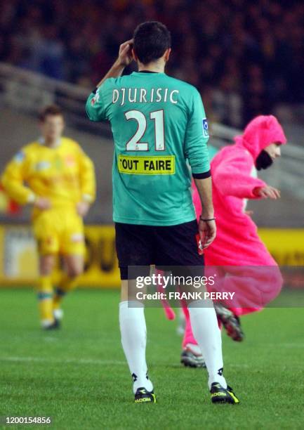 Le défenseur sedanais Dusk Djurisic regarde un homme déguisé en panthère rose courir sur la pelouse, le 22 janvier 2003 à Nantes, lors de la...