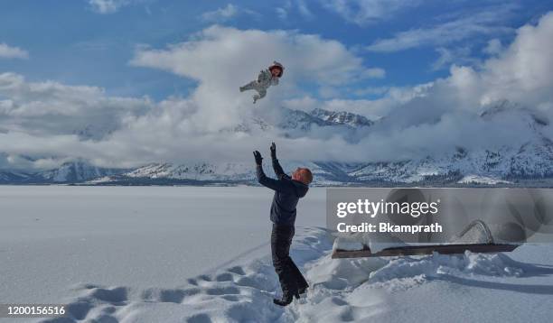 vater und tochter am jackson lake spielen im winter zu weihnachten im grand tetons national park und yellowstone national park usa - teton village stock-fotos und bilder