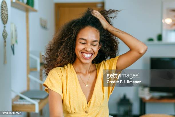 portrait of smiling woman at home - yellow dress stock pictures, royalty-free photos & images