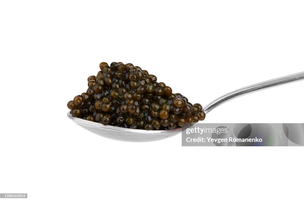 Black sturgeon caviar in silver spoon, isolated on white background