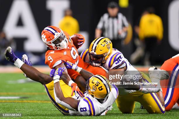 Patrick Queen and Rashard Lawrence of the LSU Tigers tackle Travis Etienne of the Clemson Tigers during the College Football Playoff National...