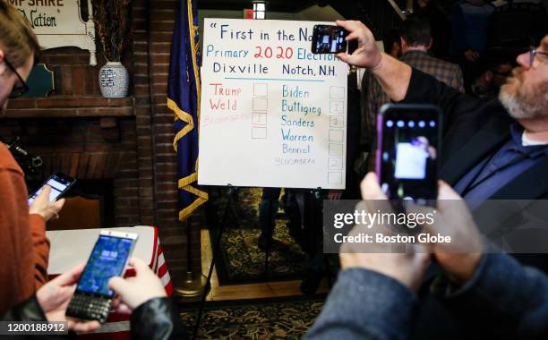 Spectators take photos of the vote count after the first-in-the-nation midnight voting tradition took place in Dixville Notch, NH on Feb. 11, 2020....