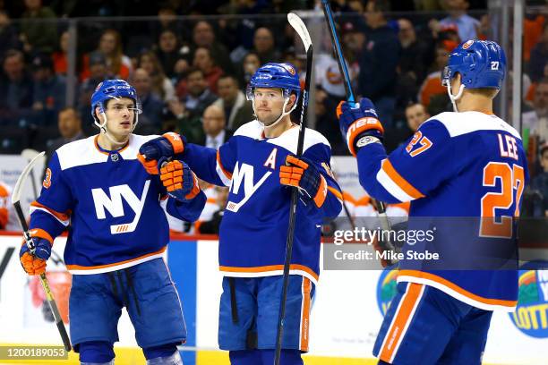 Josh Bailey of the New York Islanders is congratulated by his teammates Mathew Barzal and Anders Lee after scoring a goal against the Philadelphia...