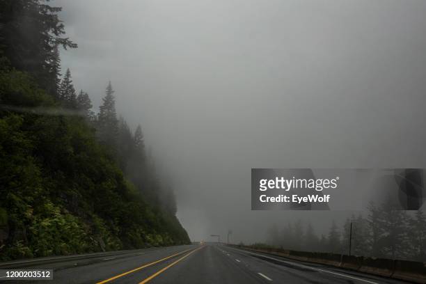 view out a car windshield at looking towards a dark storm - mountain roads stock pictures, royalty-free photos & images