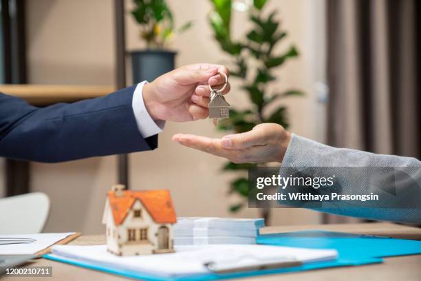 real estate agent sales manager holding filing keys to customer after signing rental lease contract of sale purchase agreement, concerning mortgage loan offer for and house insurance - real estate law stock pictures, royalty-free photos & images