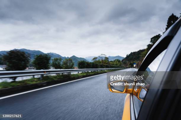 a car is driving on the mountain side road - rijden een motorvoertuig besturen stockfoto's en -beelden