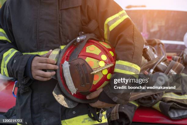 firefighters walking to the fire truck after responding an emergency call - firefighters helmet stock pictures, royalty-free photos & images