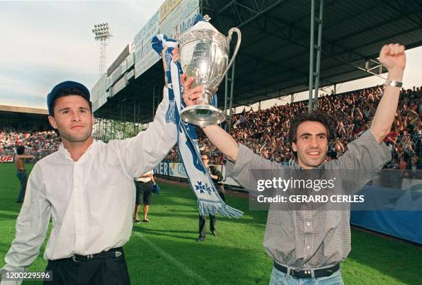 Les joueurs auxerrois Christophe Cocard et Corentin Martins brandissent le trophée de la Coupe de France devant les supporters rassemblés au stade de...