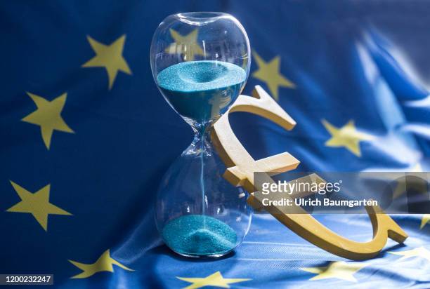 The euro, the European Union, Brexit and the global economy. The symbolic photo shows the euro logo, ajar an hourglass on the European flag.