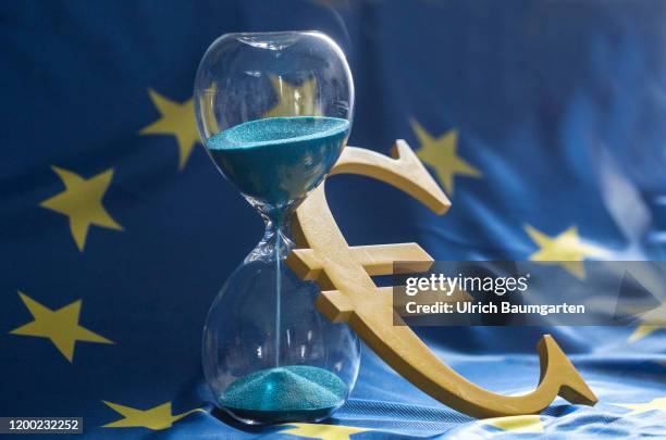 The euro, the European Union, Brexit and the global economy. The symbolic photo shows the euro logo, ajar an hourglass on the European flag.