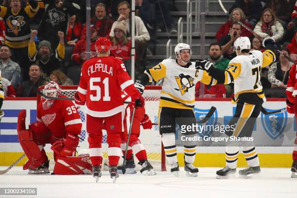 Sidney Crosby of the Pittsburgh Penguins celebrates his game winning overtime goal with Evgeni Malkin next to Jimmy Howard of the Detroit Red Wings...