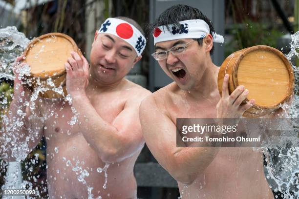Men pour ice-cold water over themselves during a purification ritual at Kanda Myojin Shrine on January 18, 2020 in Tokyo, Japan. The coming of age...