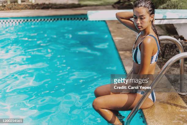 young brunette woman relaxing at the poolside - 兵士 個照片及圖片檔