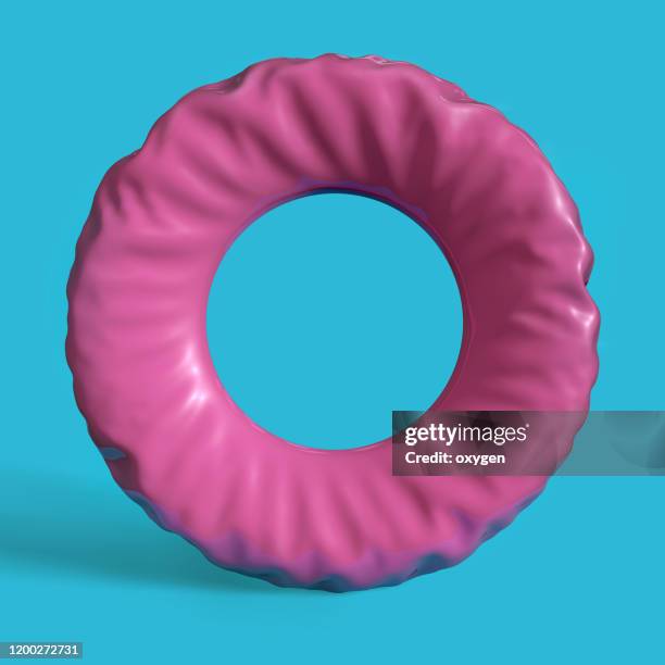 pink swim ring on blue background - rubber ring stock-fotos und bilder