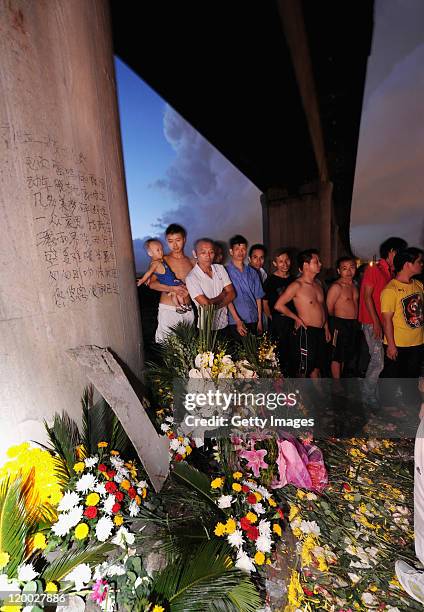 People mourn for victims who died in the Wenzhou train collision, at the accident site, on July 28, 2011 in Wenzhou, Zhejiang Province of China. The...