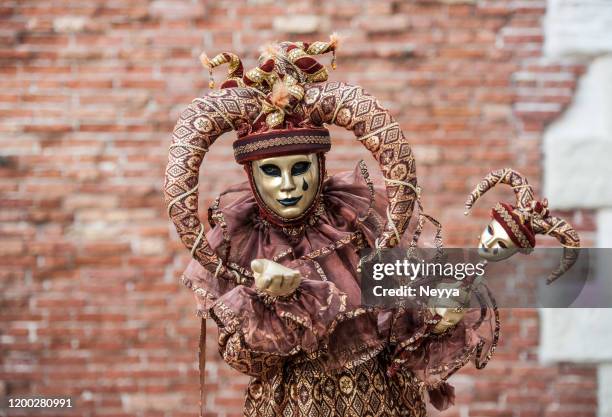 attraktive maskierte person trägt traditionelle karnevalskostüm während der venedig karneval - venezianische karnevalsmaske stock-fotos und bilder