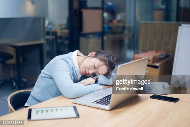tired businesswoman napping at desk by laptop in office - napping stock pictures, royalty-free photos & images