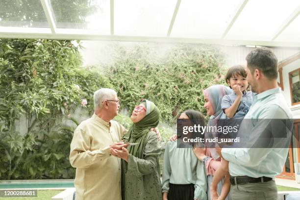famiglia multi-generazione godendo festeggiare il compleanno - muslim family foto e immagini stock