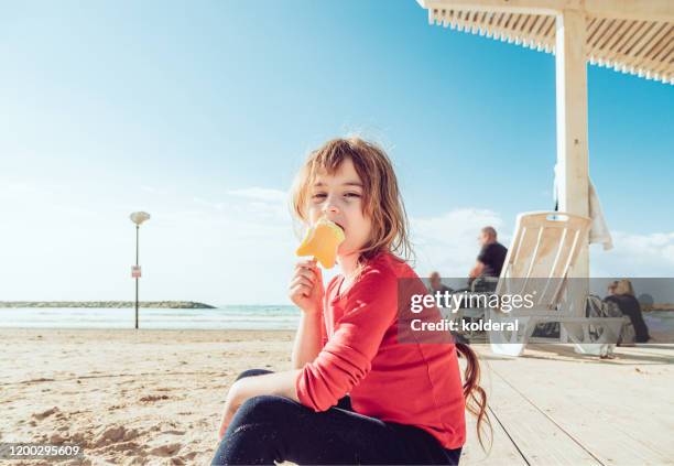 little girl eating ice cream on mediterranean beach - tel aviv stock-fotos und bilder