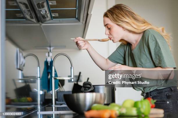 donna assaggiando il suo cibo vegetariano - soup home foto e immagini stock