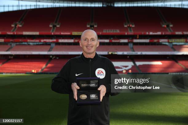 Referee Mike Dean poses for the camera with his Premier League 500 matches award prior to the Premier League match between Arsenal FC and Sheffield...