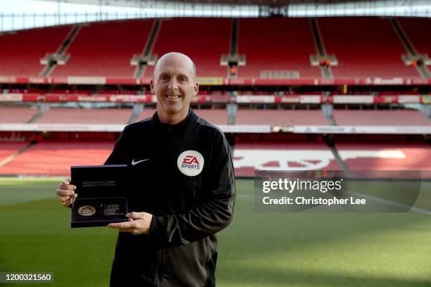 Referee Mike Dean poses for the camera with his Premier League 500 matches award prior to the Premier League match between Arsenal FC and Sheffield...