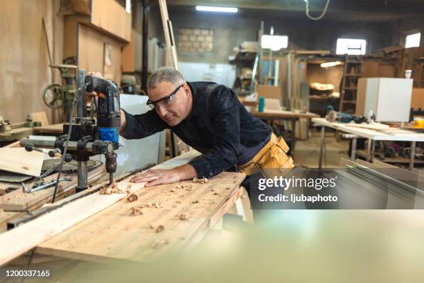 carpenter using drill press in workshop - fitter turner stock pictures, royalty-free photos & images