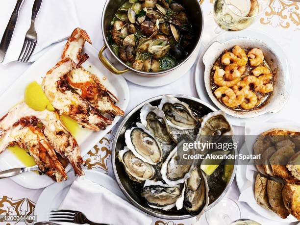 tiger prawns, oysters, clams and shrimps served in a seafood restaurant - fische und meeresfrüchte stock-fotos und bilder