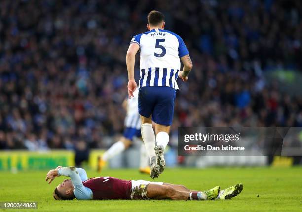 Lewis Dunk of Brighton & Hove Albion jumps over Jack Grealish of Aston Villa during the Premier League match between Brighton & Hove Albion and Aston...