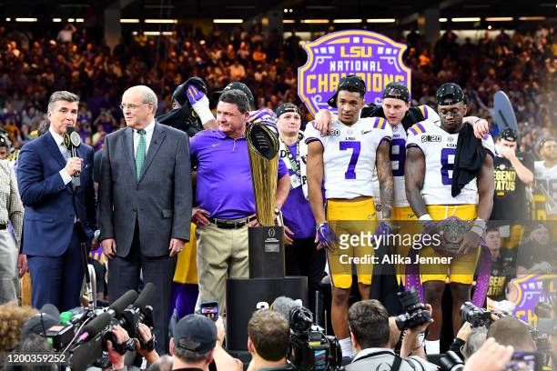 Head coach Ed Orgeron of the LSU Tigers, center left, stands on the National Championship Trophy stage with ESPN's Rese Davis, Bill Hancock,...