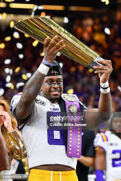 Patrick Queen of the LSU Tigers raises the National Championship Trophy after the College Football Playoff National Championship game against the...