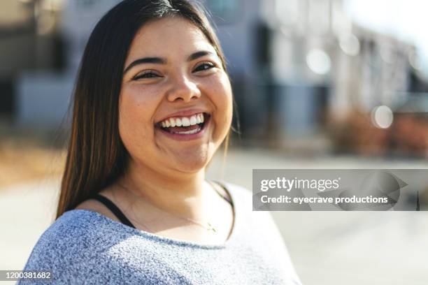 attraktive generation z junge frau der hispanischen ethnizität lächelnd für ein porträt - stadt begeisterung stock-fotos und bilder