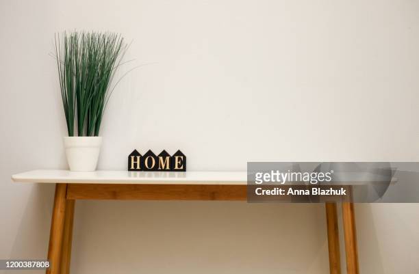 home interior details on the table, flower in pot and wooden word home - arrangiare foto e immagini stock