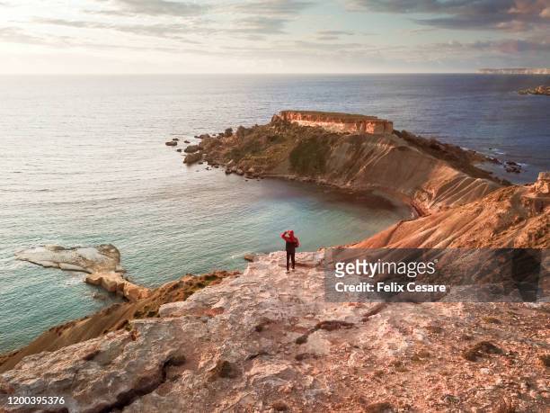 aerial view of a young man walking along the coast during winter season - malta culture stock pictures, royalty-free photos & images