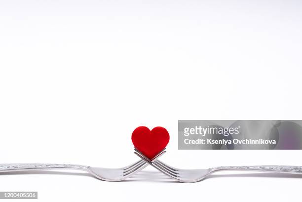 heart between two forks on a table set for two, close up - valentines day dinner foto e immagini stock