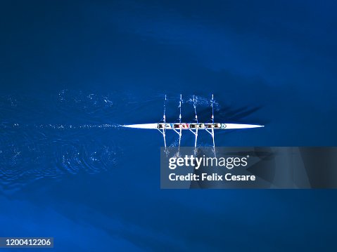 Aerial view of a rowing boat surrounded by classic blue water Aerial view of a rowing boat surrounded by classic blue water