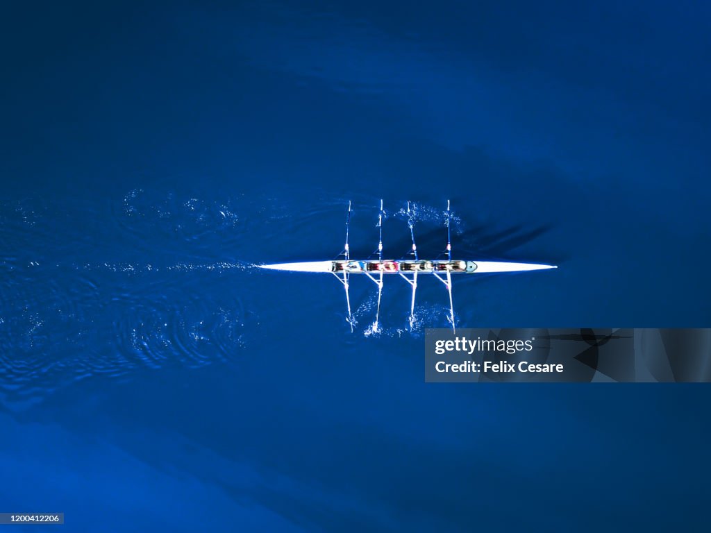 Aerial view of a rowing boat surrounded by classic blue water