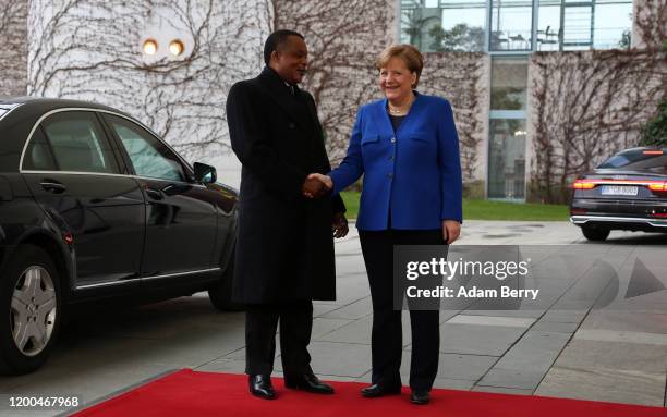 German Chancellor Angela Merkel greets Congolese President Denis Sassou-Nguesso as he arrives for an international summit on securing peace in Libya...
