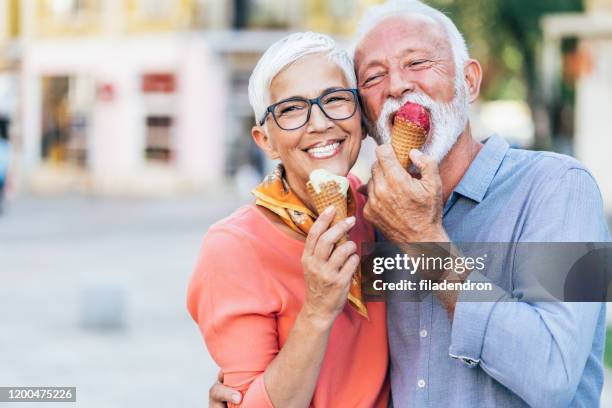 glückliches senior-paar isst eis - brille paar stock-fotos und bilder