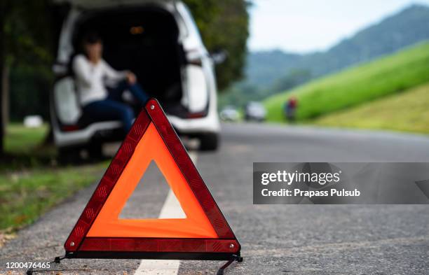 road side warning triangle, warning oncoming traffic of a broken down car, - road accident stock-fotos und bilder